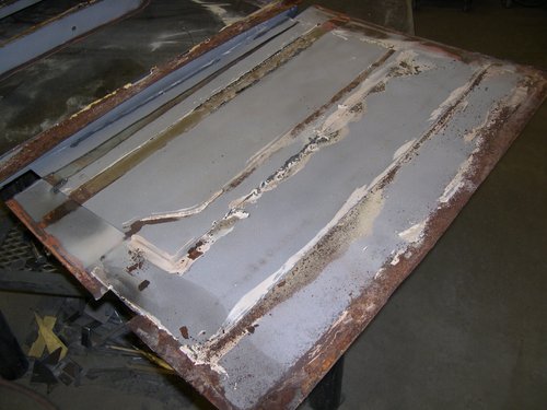   BEFORE: Here's how the old "restoration" of the door skins looked. Lap welded patch panels covered in seam sealer on the inside and lots of Bondo on the outside.  