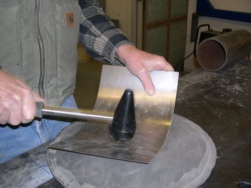   New lower cab corner patch starts taking shape with a mallet and shot bag.  